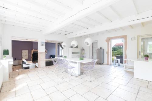 a living room with a table and chairs at Le Clos des Vignes in Loisy