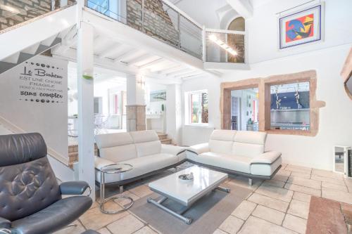 a living room with white furniture and a staircase at Le Clos des Vignes in Loisy