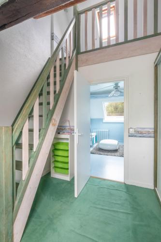 a room with a staircase and green flooring at Le Clos des Vignes in Loisy