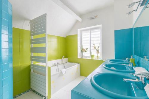 a bathroom with blue and green walls and four sinks at Le Clos des Vignes in Loisy