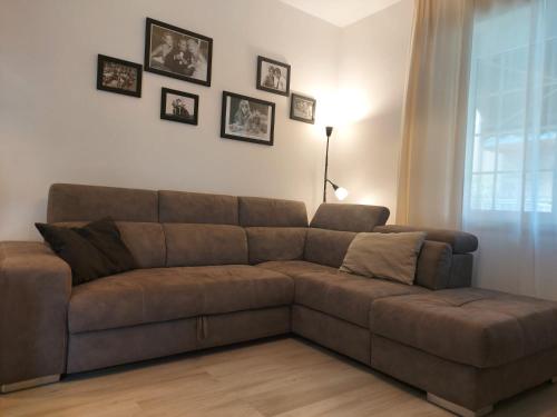 a brown couch in a living room with pictures on the wall at Bergamo - La Casa Di Gianna in Nembro