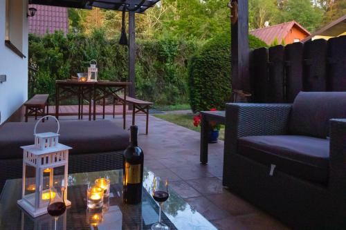 Una botella de vino sobre una mesa de cristal en un patio. en ROWY BIAŁA MEWA Dom Wakacyjny, en Rowy