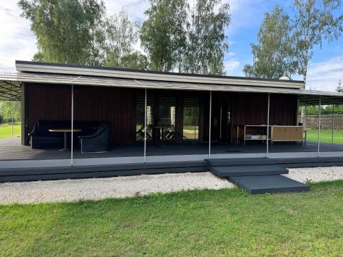 a pavilion with a table and chairs in a field at Daugava in Aizkraukle