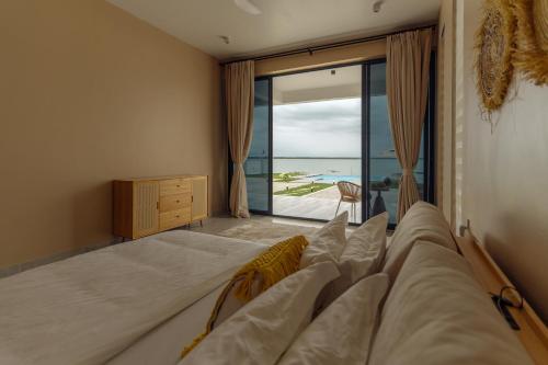 a bedroom with a bed with a view of the ocean at Tulia Luxury Villas in Mkunguni