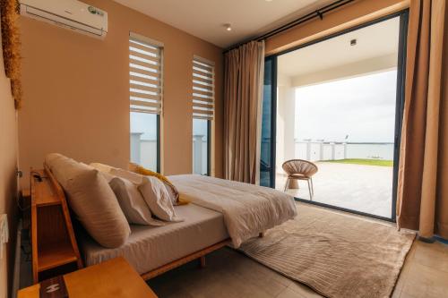 a bedroom with a bed and a large window at Tulia Luxury Villas in Mkunguni