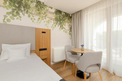 a bedroom with a bed and a table and chairs at Chaber Apartamenty in Swornegacie 