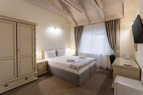 a bedroom with a bed and a desk and a window at GENESIS by Eden in Predeal