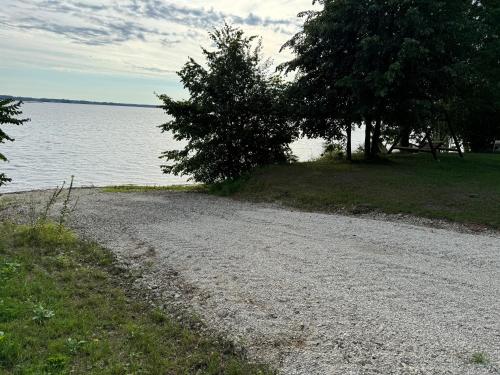 a gravel road next to a body of water at Daugava in Aizkraukle