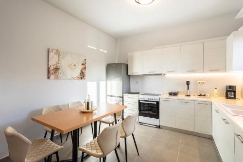 a kitchen with white cabinets and a wooden table at Filiatra Charming Urban Escape Your Cozy Retreat in Filiatra