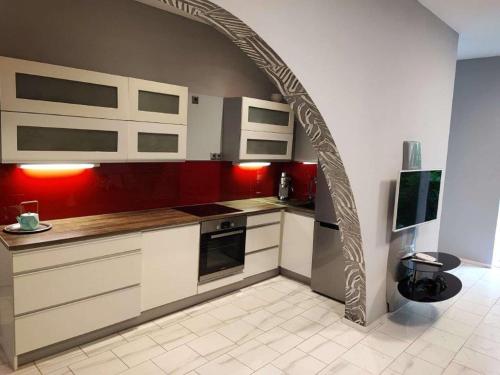 an archway in a kitchen with red and white cabinets at Central Vienna Apartment with unique 40m2 city garden & self check in in Vienna