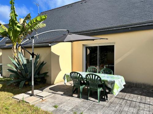 a patio with a table and chairs and an umbrella at 1002 - Maison 5p à 1km de la Plage des Vallées in Pléneuf-Val-André