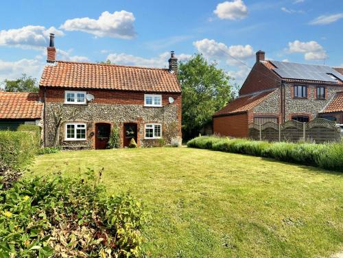 a house with a large yard in front of it at Wren Cottage North Norfolk in Hindringham