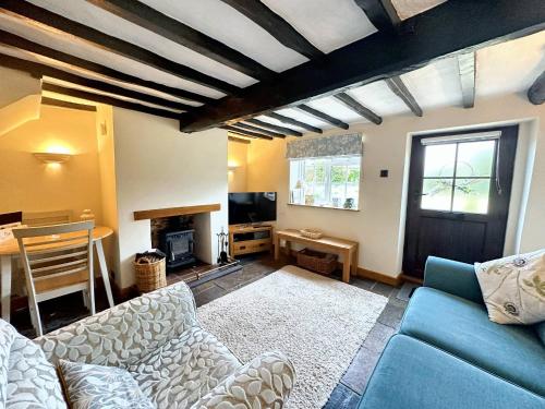 a living room with a couch and a table at Wren Cottage North Norfolk in Hindringham