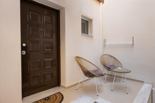 two chairs and a door in a room at Valery Apartments in Pefkohori