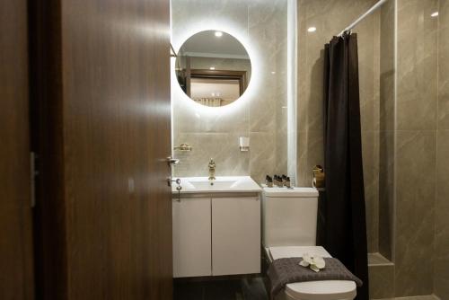 a bathroom with a sink and a toilet and a mirror at Valery Apartments in Pefkohori