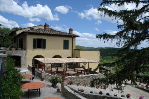 a building with tables and a patio in front of it at Hotel Villa Casalecchi in Castellina in Chianti