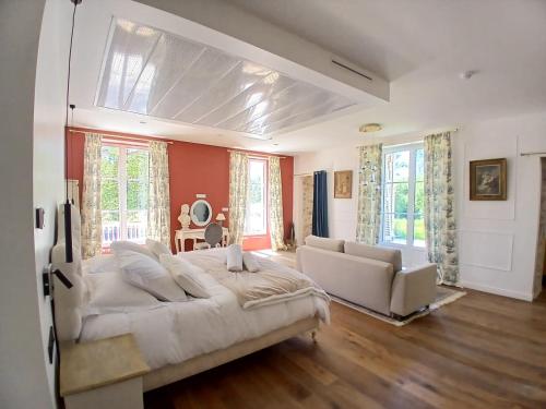 a large bedroom with a large bed and a couch at Château de la PLUMASSERIE in Fontenay-Trésigny