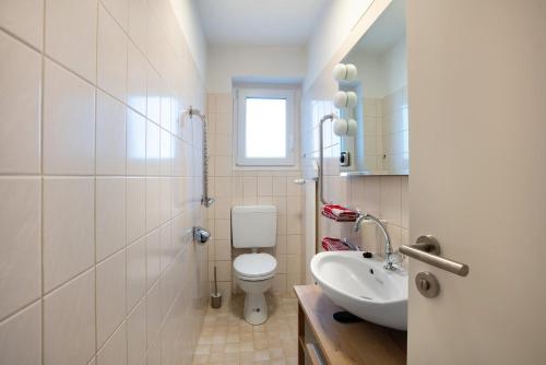 a white bathroom with a toilet and a sink at Familie Quednow - Im Algi in Görwihl