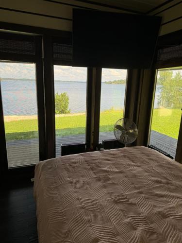a bedroom with a bed and a view of the water at Daugava in Aizkraukle