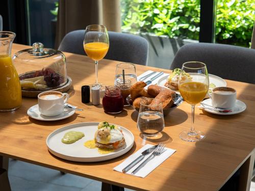 a wooden table with plates of food and glasses of drinks at LMS - La Maison Suisse - Döttingen in Döttingen