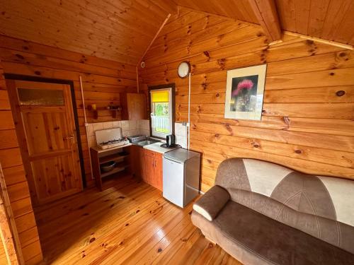 a room with a bed and a kitchen in a cabin at Bieszczady Pod Dębem Solina in Solina
