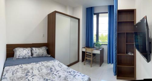 a bedroom with a bed and a desk and a window at CH Home in Danang