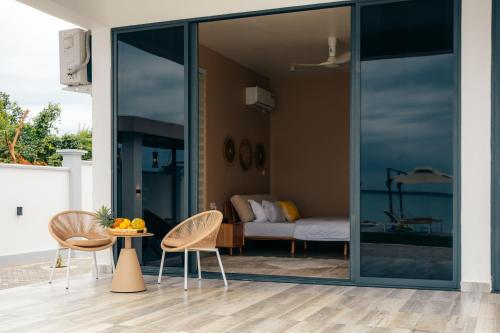 a room with glass doors and a table and chairs at Tulia Luxury Villas in Mkunguni