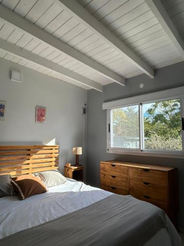 a bedroom with a large bed and a window at Entre Las Sierras Tiny House Cabañas in Villa Giardino