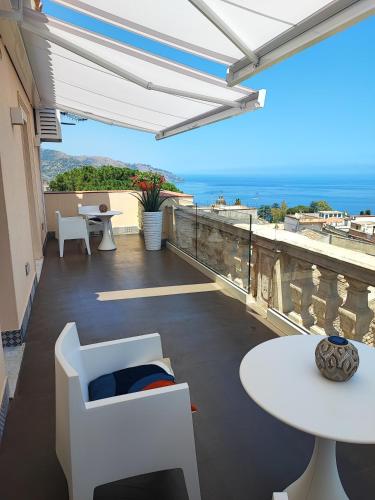 a balcony with white furniture and a view of the ocean at La Terrazza di Porta Messina in Taormina