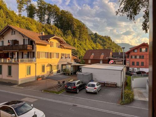 two cars parked in a parking lot next to a house at City Center View Apartment 2 in Interlaken