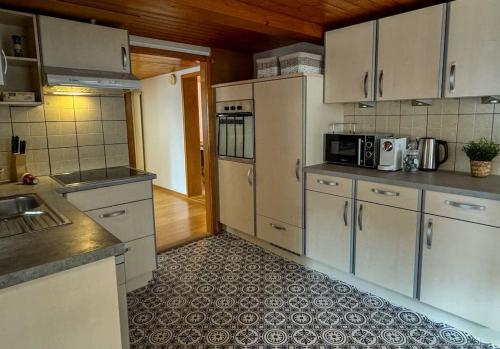 a kitchen with white cabinets and a tile floor at City Center View Apartment in Interlaken