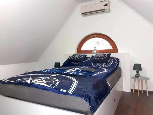 a bedroom with a bed with a blue comforter at Arena Apartman Siófok in Siófok
