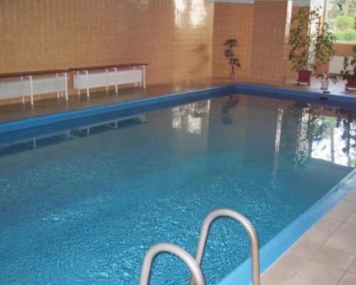 a large swimming pool with blue water in a building at Ferienwohnung Filli mit Sauna und Pool im Haus in Prien am Chiemsee