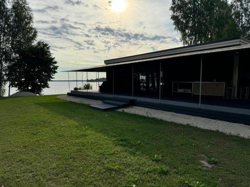 a building with a grassy yard next to the water at Daugava in Aizkraukle