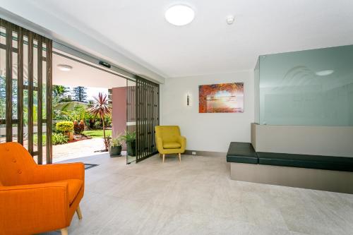 a living room with a couch and a yellow chair at Surfers Beachside Holiday Apartments in Gold Coast