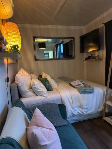 a bedroom with a bed and a mirror and a couch at Tiny Home Beach Serenity! in Sydney