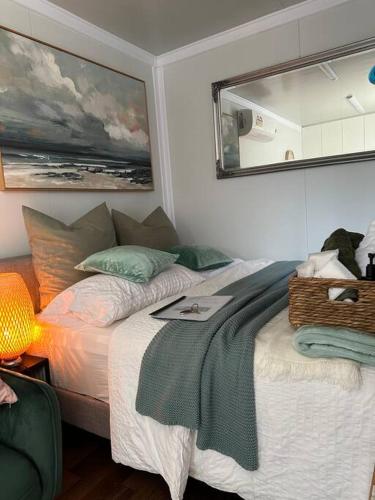 a bedroom with a bed with a mirror on the wall at Tiny Home Beach Serenity! in Sydney