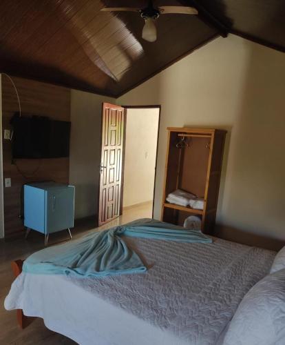 a bedroom with a bed and a dresser and a mirror at Pousada Raio de Luz in Pirenópolis