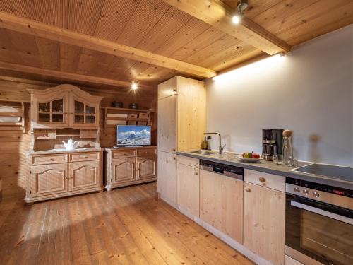 cocina grande con armarios de madera y suelo de madera en Appartement Bergfried, en Westendorf