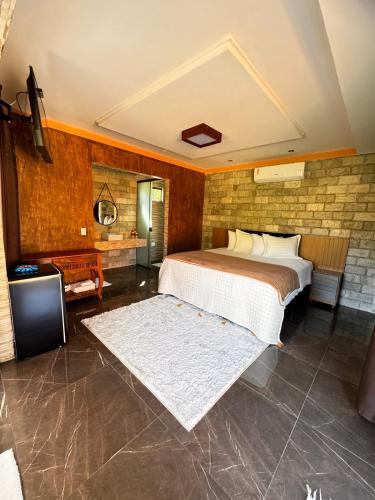 a bedroom with a bed and a tv in a room at Pousada Raio de Luz in Pirenópolis