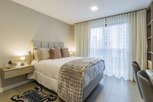 a bedroom with a bed and a large window at GO 24 by My Way in Porto Alegre