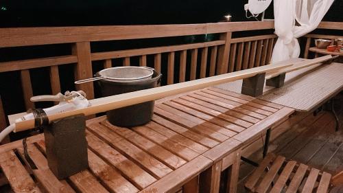 a wooden bench with a trash can on a balcony at 桃の木別荘　Momonoki Villa in Hita