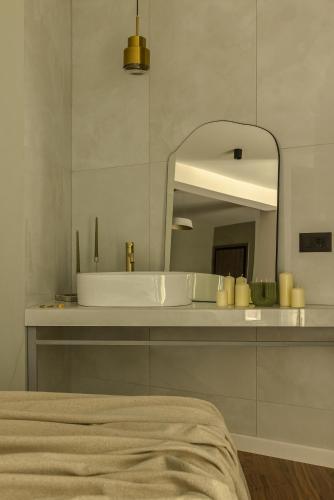 a white bathroom with a sink and a mirror at The Offset in Ioannina