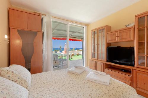 a bedroom with a bed and a tv and a balcony at Azahara Beach in Arona