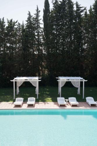 a couple of tables and chairs next to a pool at Antica Masseria Martuccio in Mesagne