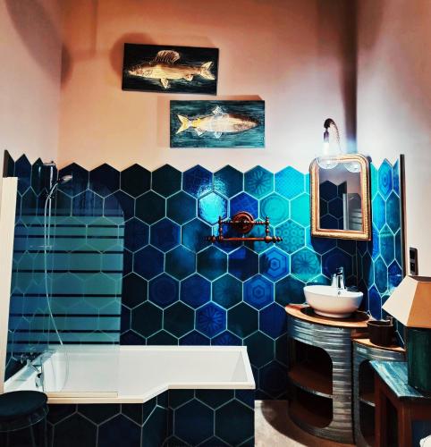 La salle de bains est pourvue d'un lavabo et d'un mur carrelé bleu. dans l'établissement Ô Rêves Ailleurs, à Saint-Cyr-sur-Mer