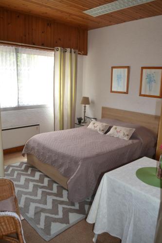 une chambre avec un grand lit et une fenêtre dans l'établissement Les Fromentines, à Saint-Pol-de-Léon