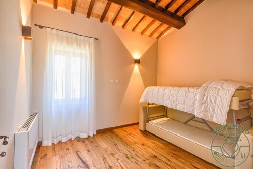 a bedroom with a bed and a window at Agriturismo Colli Martani in Massa Martana