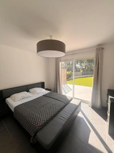 une chambre avec un lit et une grande fenêtre dans l'établissement Villa Paesolu piscine chauffée charme et sérénité, à Porto-Vecchio