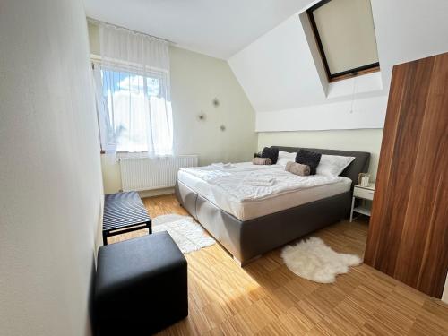 a bedroom with a bed and a chair at tettyeapartman in Pécs